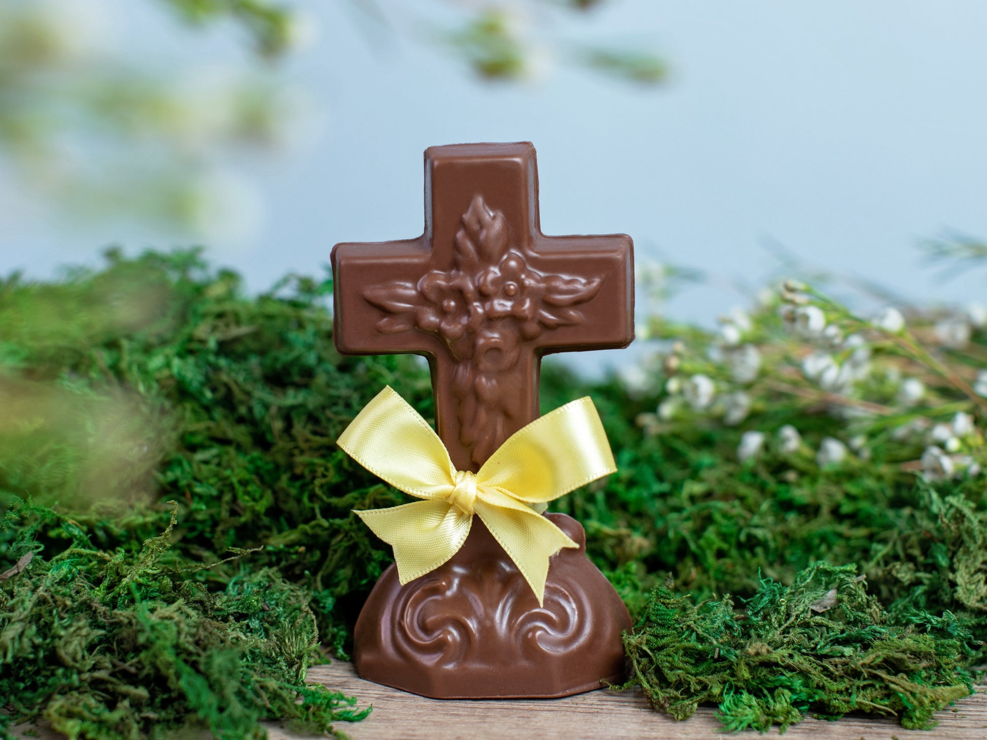 an ornate chocolate cross with a yellow ribbon.