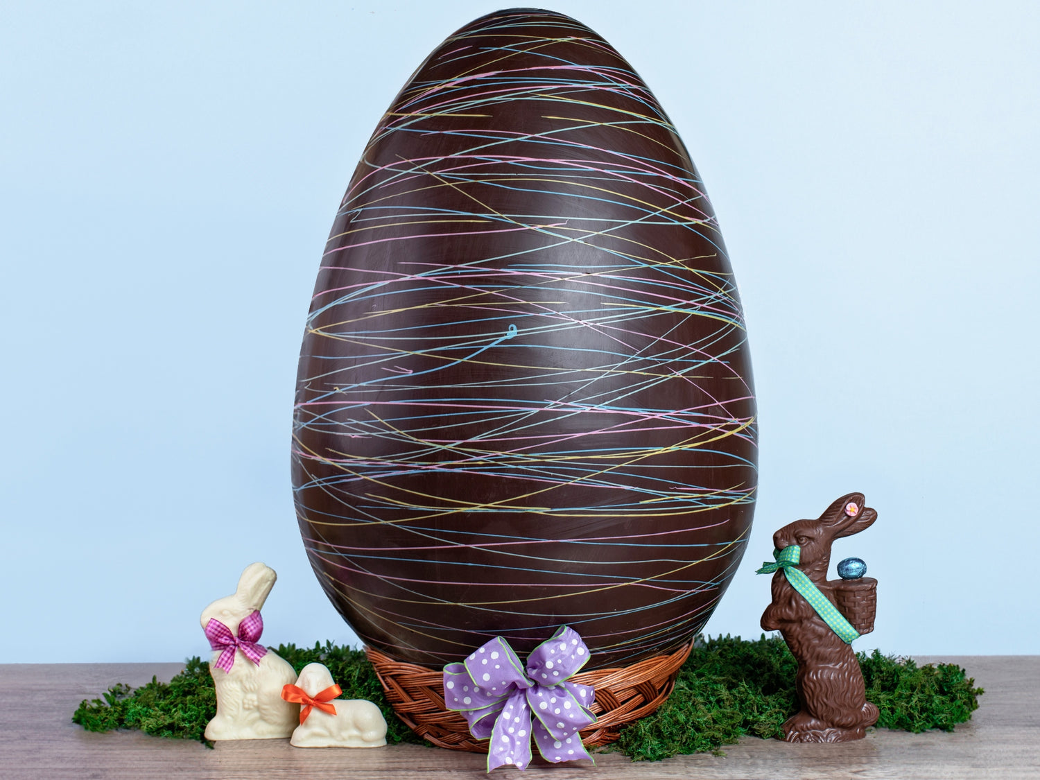 a very large chocolate egg decorated with colorful  drizzle