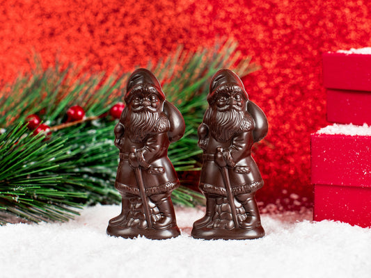 small molded chocolate Santas carrying a toy sack and a stick