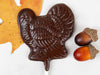 A dark chocolate turkey pop with two acorns for decoration