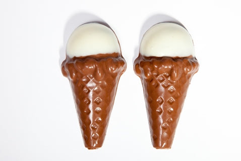 two tiny chocolate molded Ice Cream Cones have white chocolate 'vanilla' scoops in them.