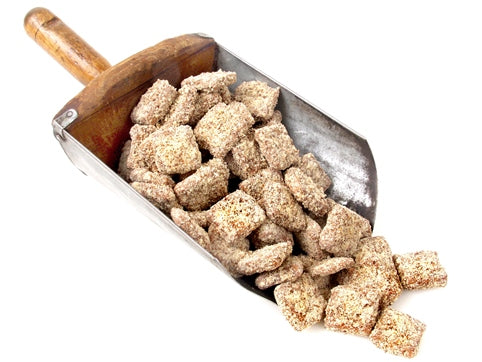 An old-fashioned metal and wooden scoop holds a generous portion of butter crunch squares. 